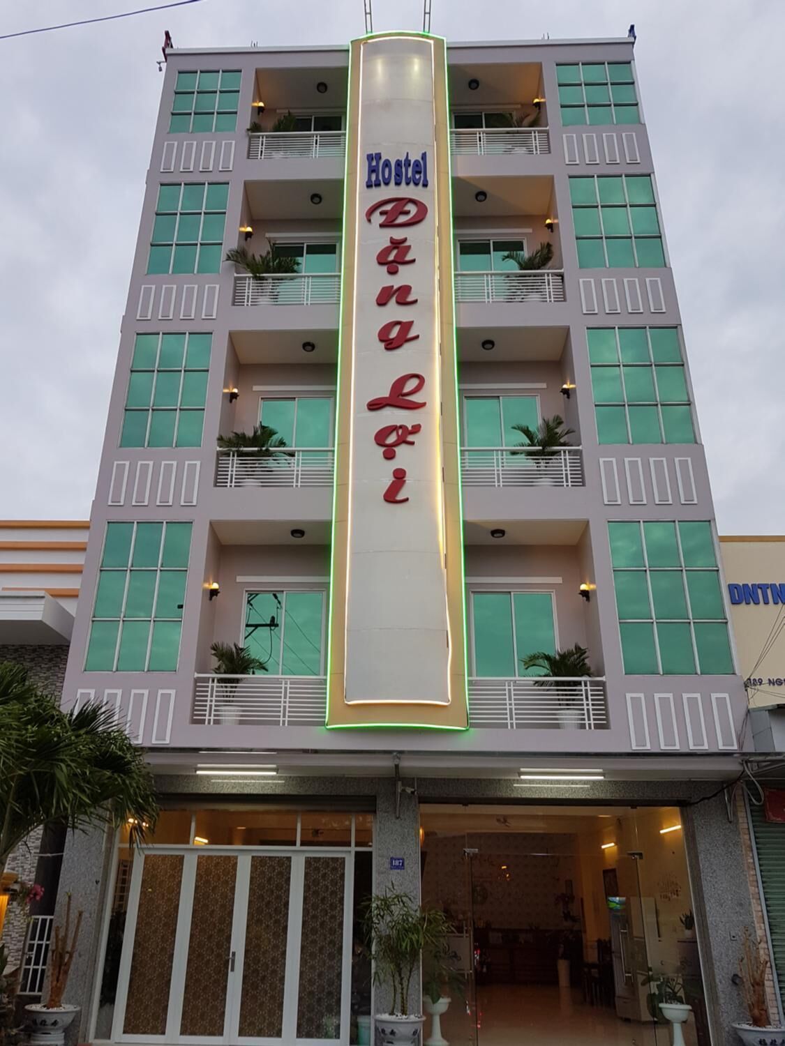 A multi-story building with a prominent vertical sign reading "Hostel D'Angelo".