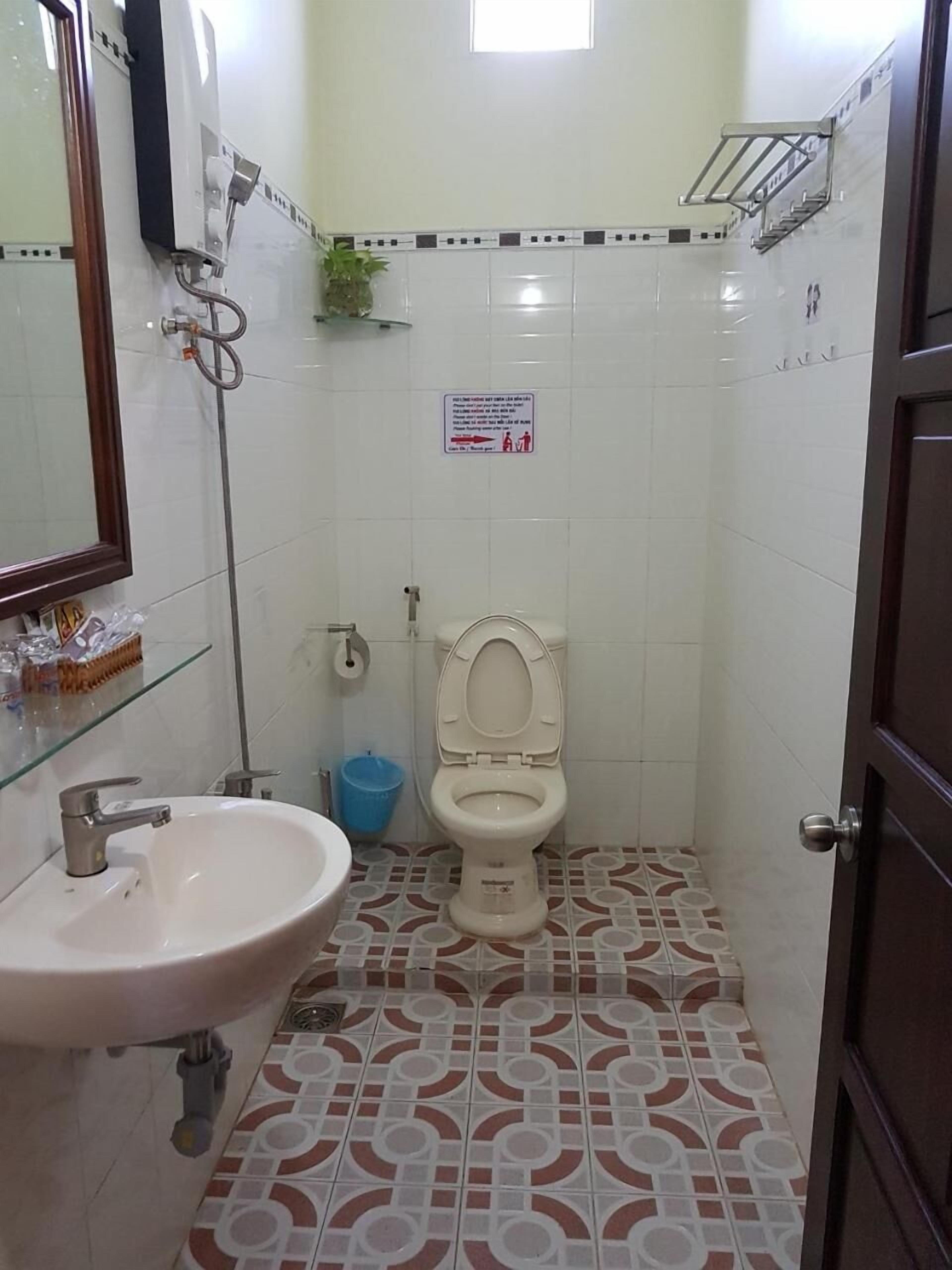 A small bathroom with a toilet, sink, and a shower.