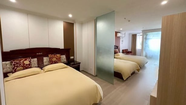 A hotel room with two beds, a large mirror, and a view of a balcony. - Zhuoting Hotel (Pinghu)