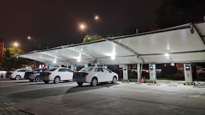 A parking area with multiple cars and electric vehicle charging stations. - Zhuoting Hotel (Pinghu)