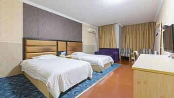 Een hotelkamer met twee bedden, een bureau, een stoel en een televisie.
