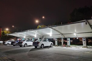 A covered parking area with multiple cars parked under a canopy.