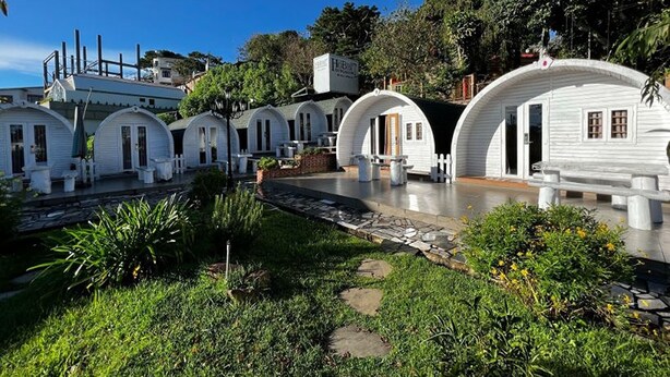 A row of white, dome-shaped cabins with a stone pathway leading to them, surrounded by greenery. - HB Bungalow (Xuan Huong - Da Lat)