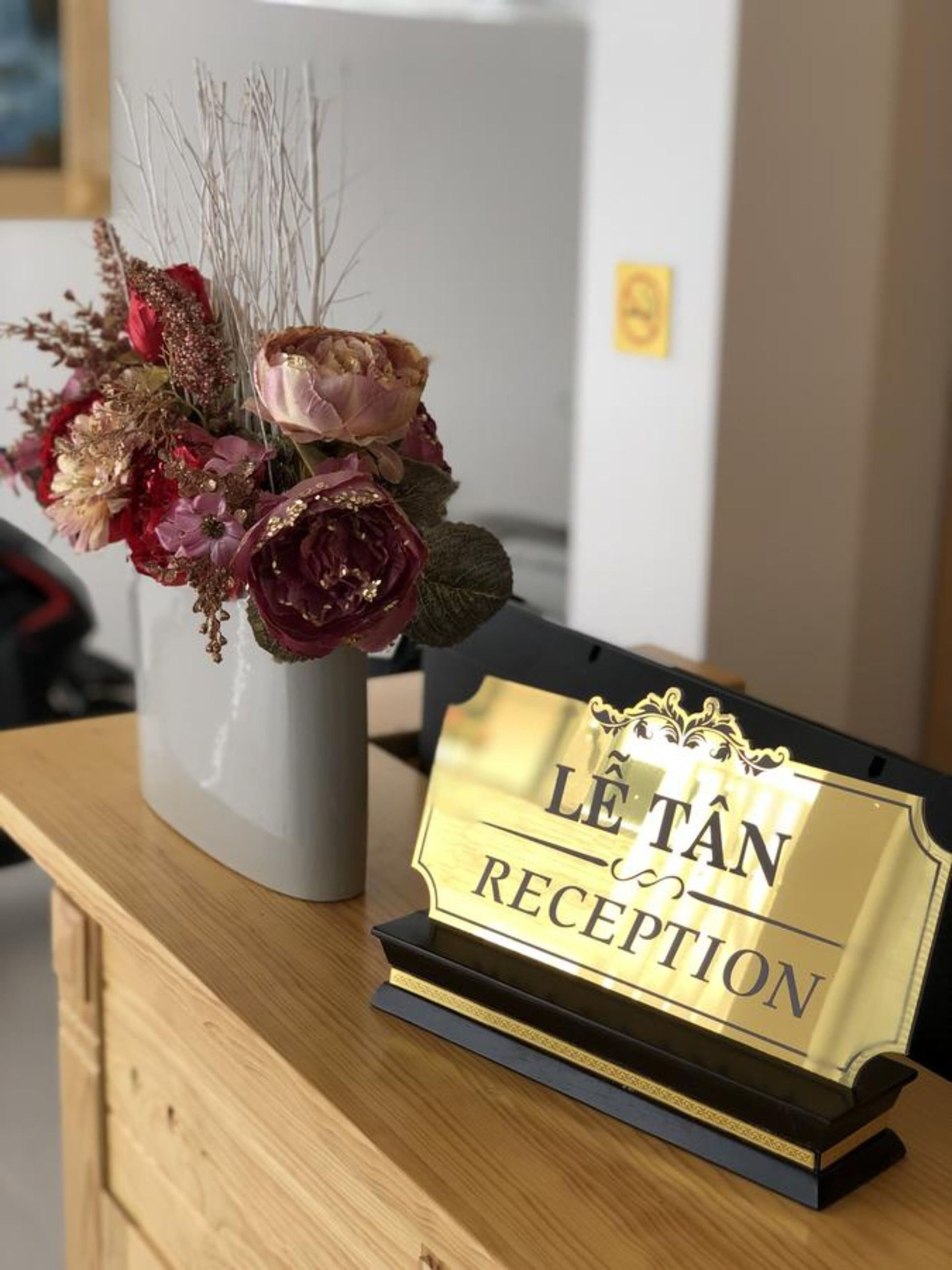 Una recepción con un cartel que dice "L'ETAN RECEPTION" y un florero con flores.