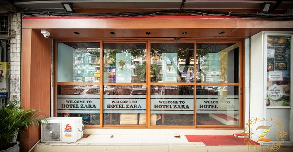 A hotel entrance with a sign reading "Welcome to Hotel Zara" and a security camera above the door. - Hotel Zara (Yangon)