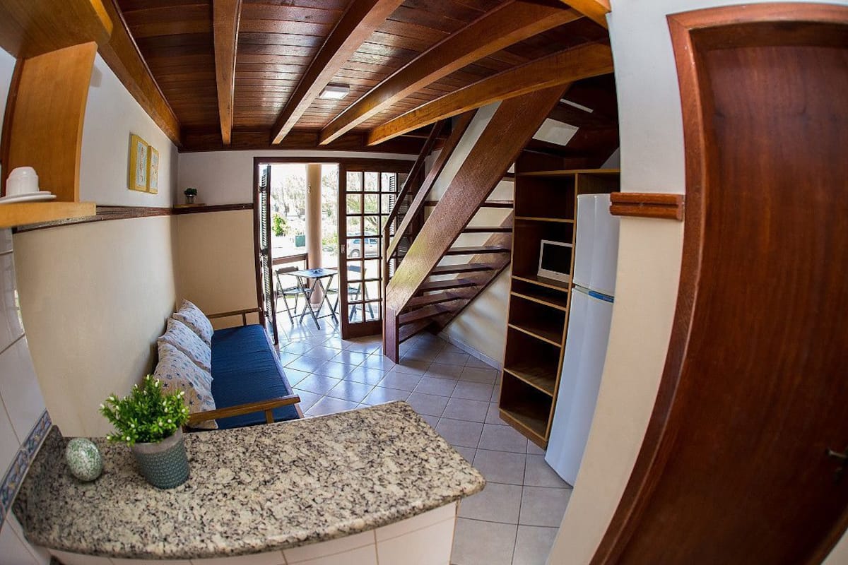 Una cocina con encimera de granito, estufa empotrada y techo de madera.
