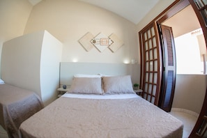 Un dormitorio con una cama, dos mesitas de noche y un cuadro colgado en la pared.