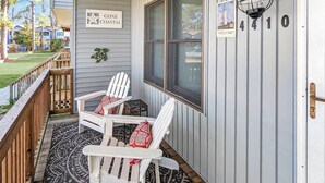 Un porche avec deux fauteuils Adirondack, une pancarte de bienvenue et le numéro de la maison, 4100.