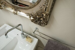 A bathroom with a white sink, a mirror with ornate silver framing, and a towel rack. - Rural paradise with rainforest views (Eureka)