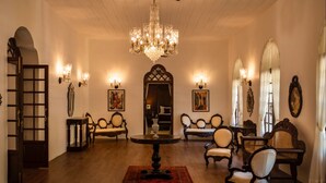 A spacious room with a high ceiling, ornate chandeliers, and classic furniture. - The Postcard Cuelim (Consua)