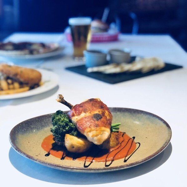 Una mesa con platos de comida, una cerveza y una taza.