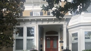 A two-story house with a front porch, a double door, and a brick foundation. - Charming Condo in Downtown Wilmington’s Historic District (Wilmington)