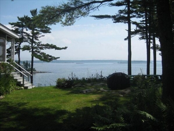A view of a lake from a house with a staircase leading to a porch.