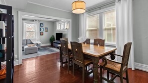 A dining area with a wooden table and chairs, a chandelier, and a view of a living room with a sofa and a fireplace. - Family Friendly , Fully Renovated 3BR Luxury Home. Centrally located in St.Louis (St. Louis)