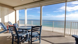 A balcony with a table and chairs, overlooking a beach and ocean. - Regency Isle 608 by Liquid Life (Orange Beach)