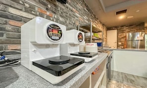 A kitchen with two coffee machines on a granite countertop, a brick wall, and a stainless steel refrigerator in the background. - HOTEL Yeogiuhtte Gwangju Hanam (Gwangju)