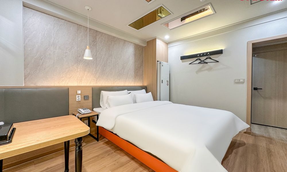 Une chambre d’hôtel avec un lit, une table de chevet et un bureau.