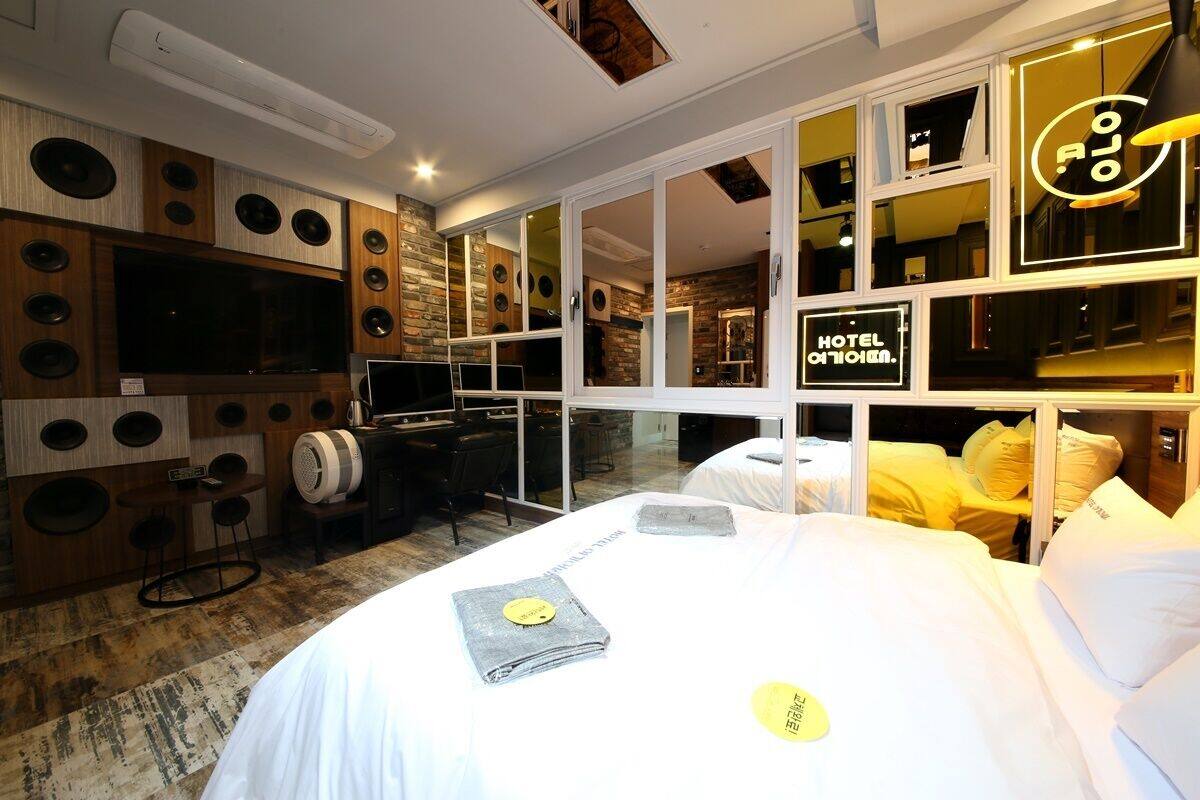 Una habitación de hotel con una cama grande, un televisor, un escritorio y una zona de estar con una mesa y sillas.