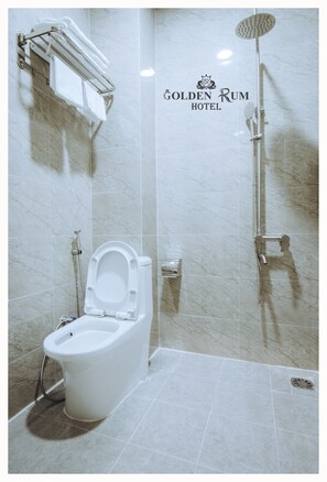 A modern bathroom with a toilet, shower, and a towel rack. - Golden Rum Hotel (Xuan Huong - Da Lat)