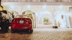 The exterior of the Golden Rum Hotel with a red car parked in front. - Golden Rum Hotel (Xuan Huong - Da Lat)
