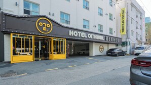 Fachada de hotel en amarillo y negro, con un letrero que dice 