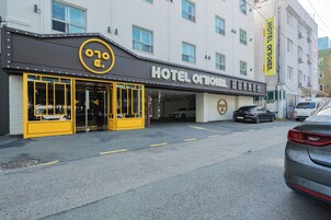 Fachada de hotel en amarillo y negro, con un letrero que dice