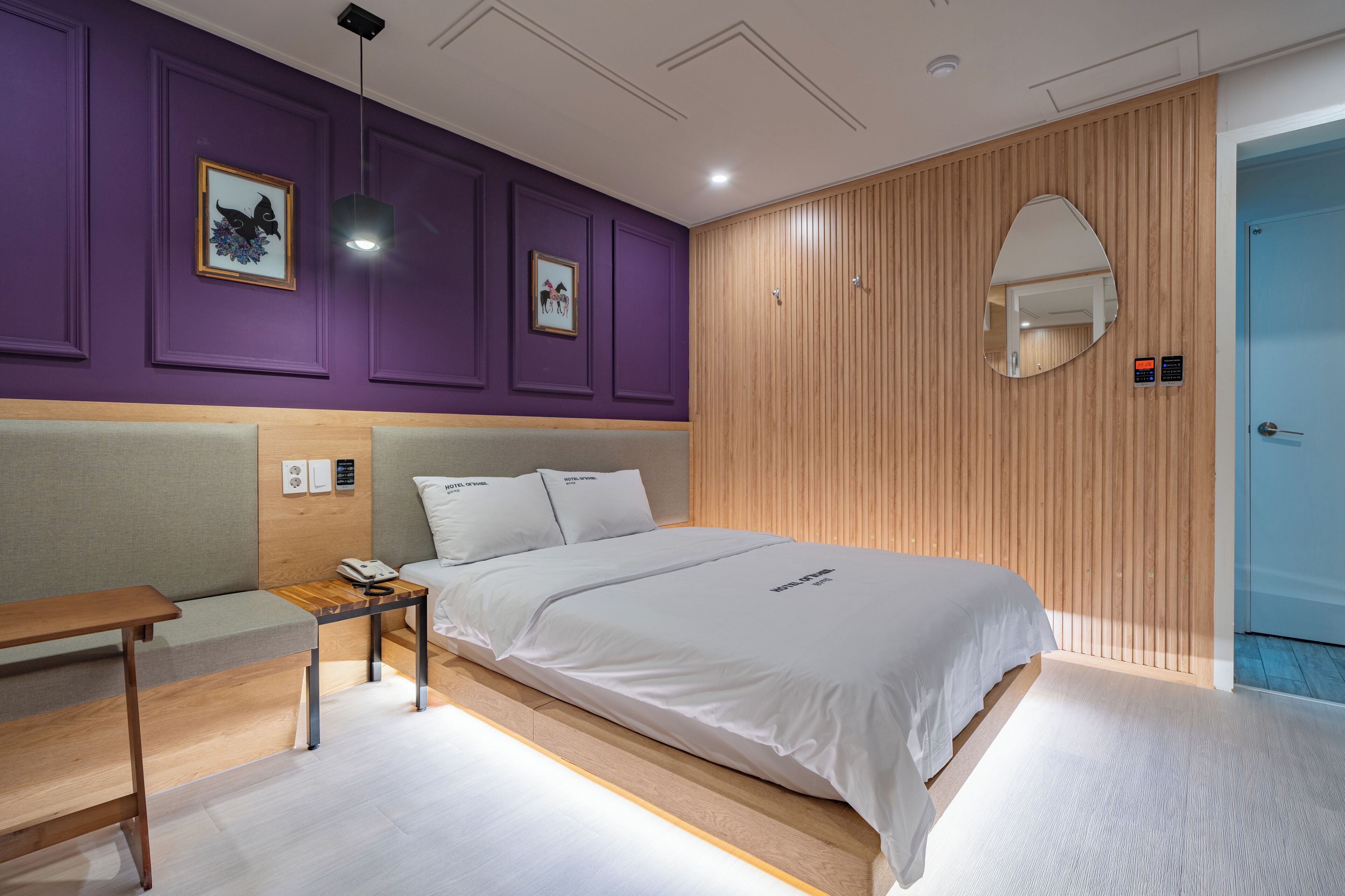 Ein modernes Schlafzimmer mit einem großen Bett, einem Nachttisch und einem hölzernen Kopfteil.