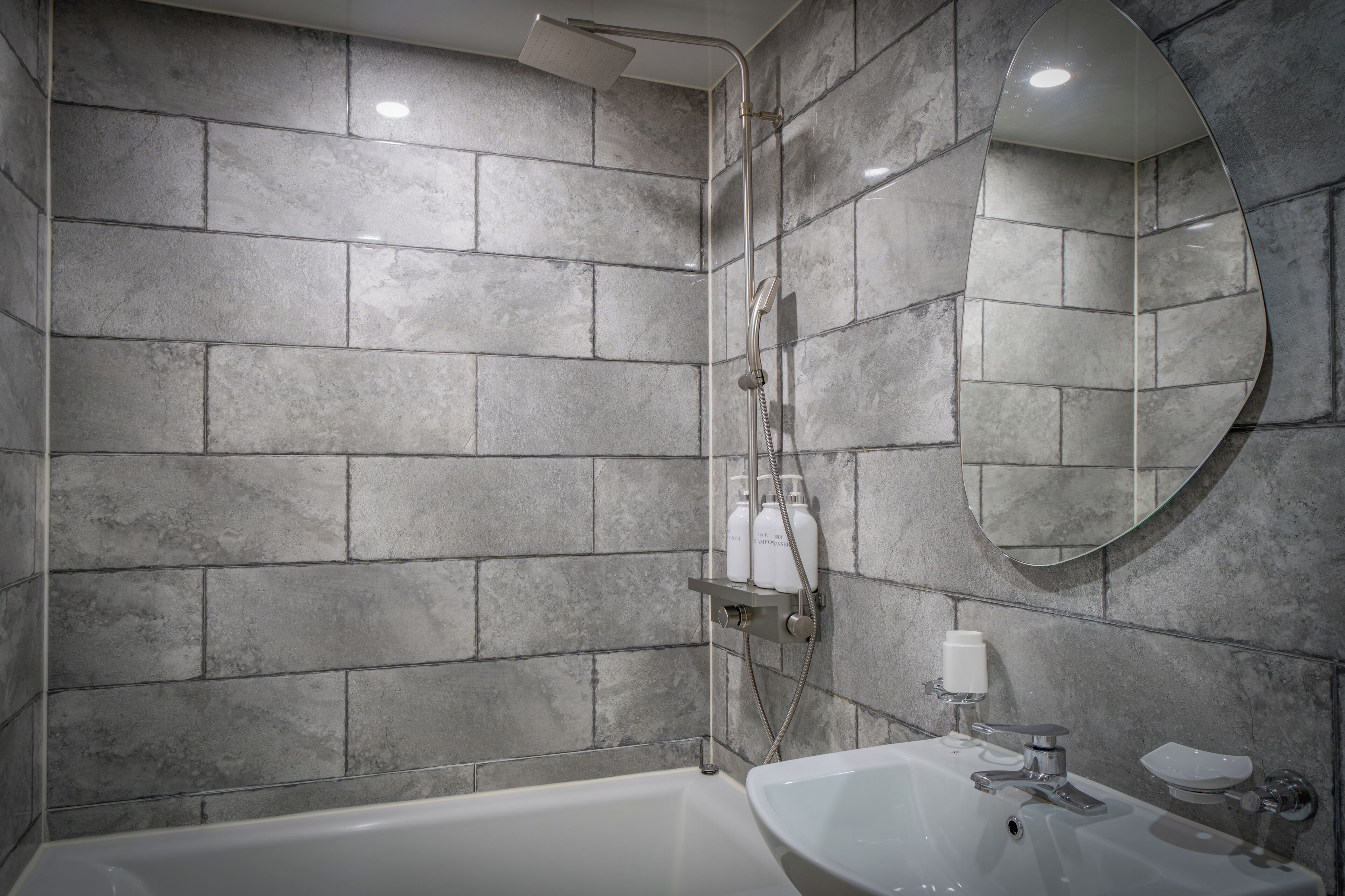 A modern bathroom with a bathtub, a sink, and a shower.