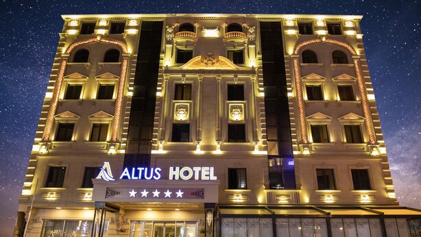 The exterior of the Altus Hotel with illuminated signage and a star rating of four and a half stars. -  Altus Hotel Baku - Free Massage (Baku)