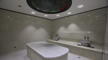 Bathroom features a bathtub, mosaic tile walls, and a bench with sink and mirror.