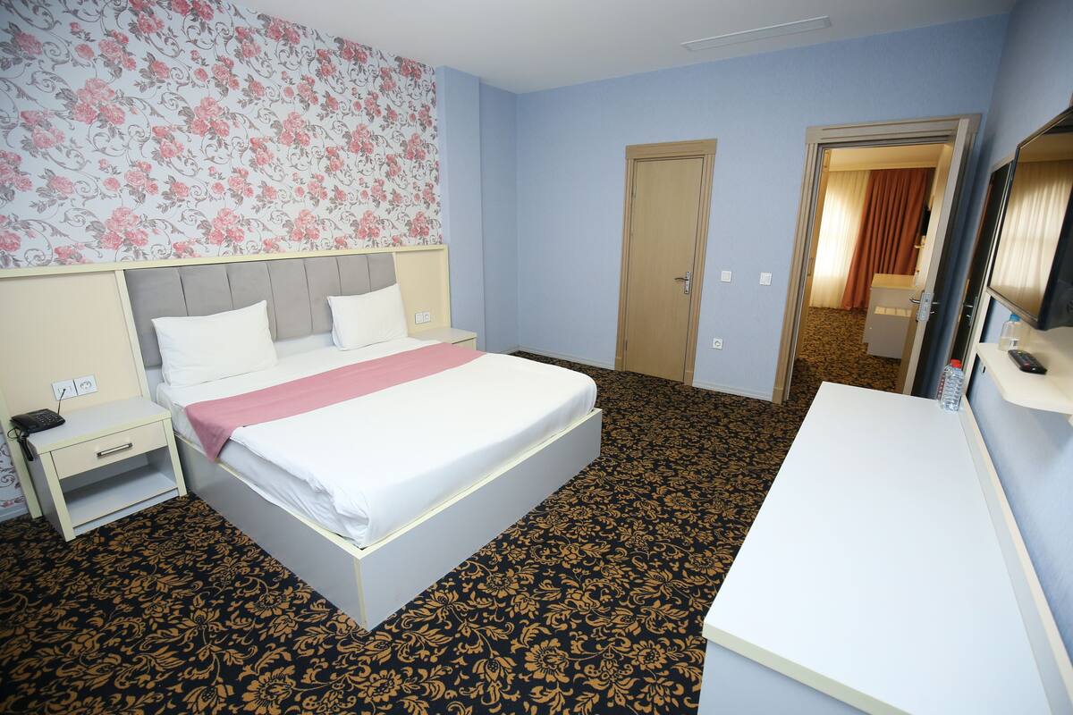 Une chambre d’hôtel avec un lit, une table de chevet et un bureau.