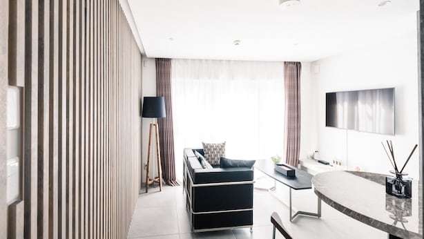 A modern living room with a sofa, a coffee table, and a TV mounted on the wall. - Spatium Ginza (Tokyo)