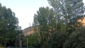 Une piscine rectangulaire à l’eau d’un bleu limpide, entourée d’une terrasse en briques. On aperçoit une chaise flottante rouge et un panier de basketball sur le côté droit de la piscine.