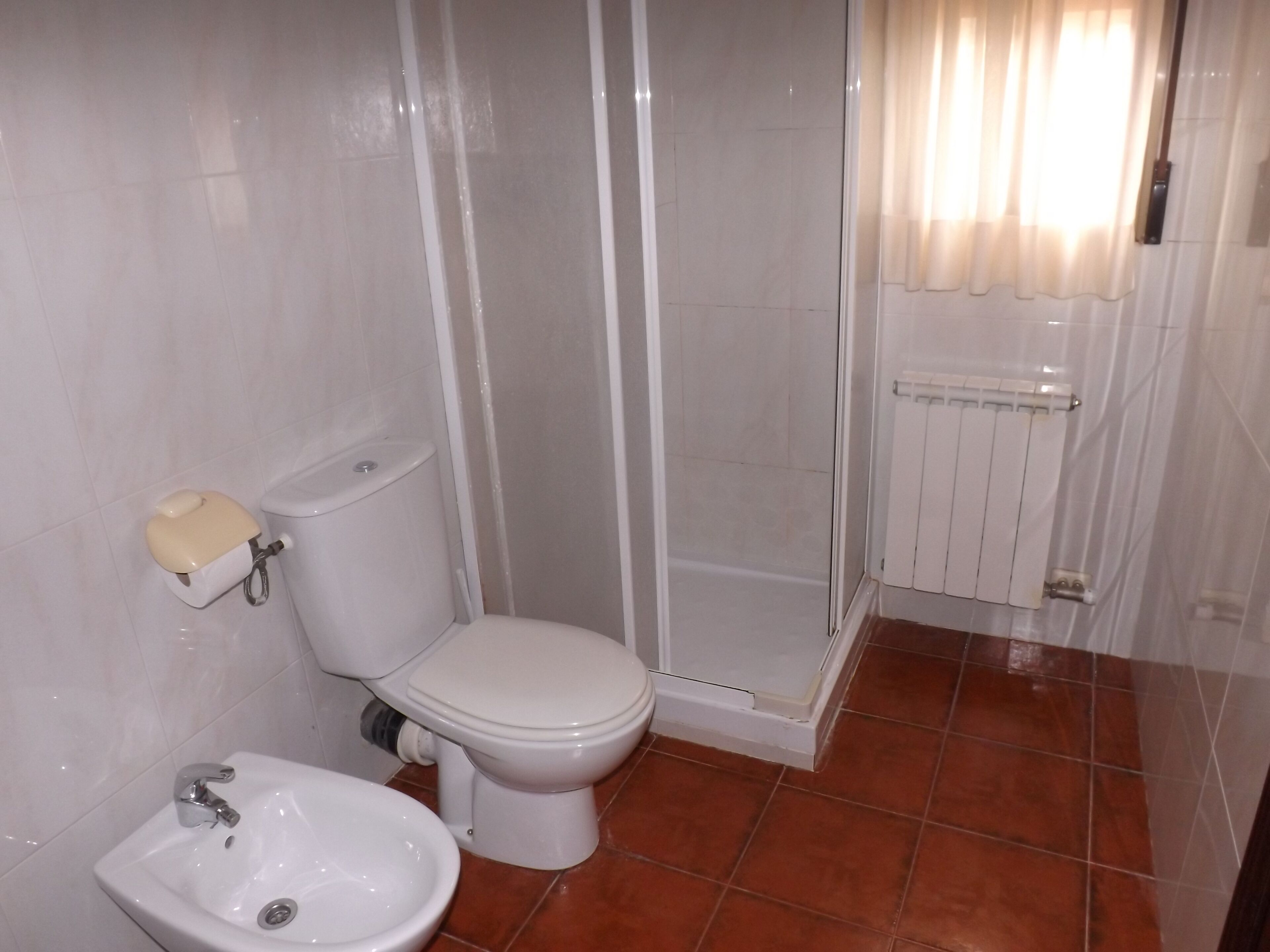 Une salle de bain comprenant des toilettes, un bidet et un espace douche.