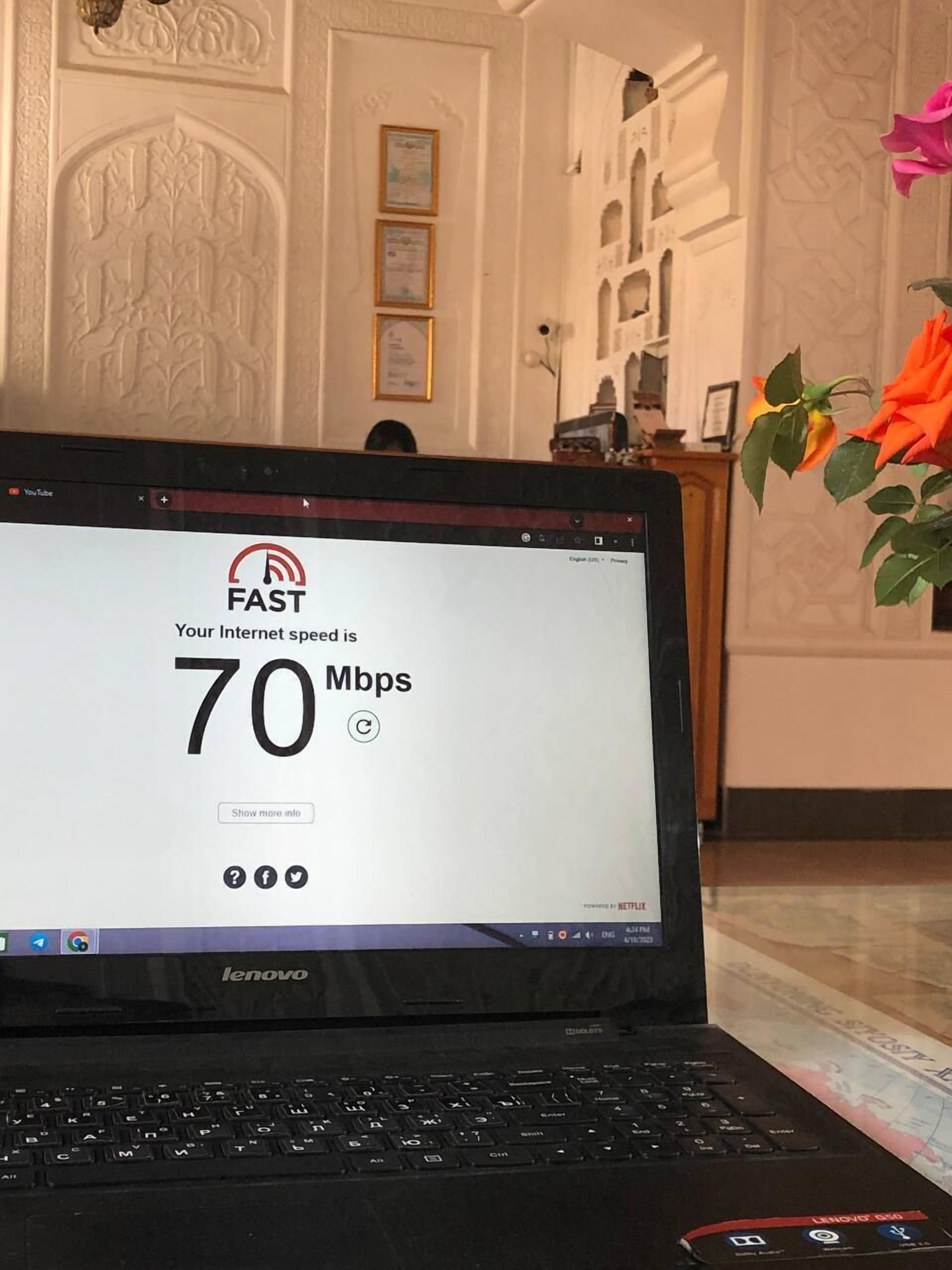 A laptop displaying an internet speed test result of 70 Mbps.
