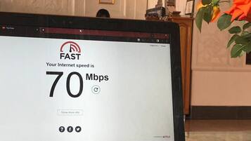 A laptop displaying an internet speed test result of 70 Mbps.