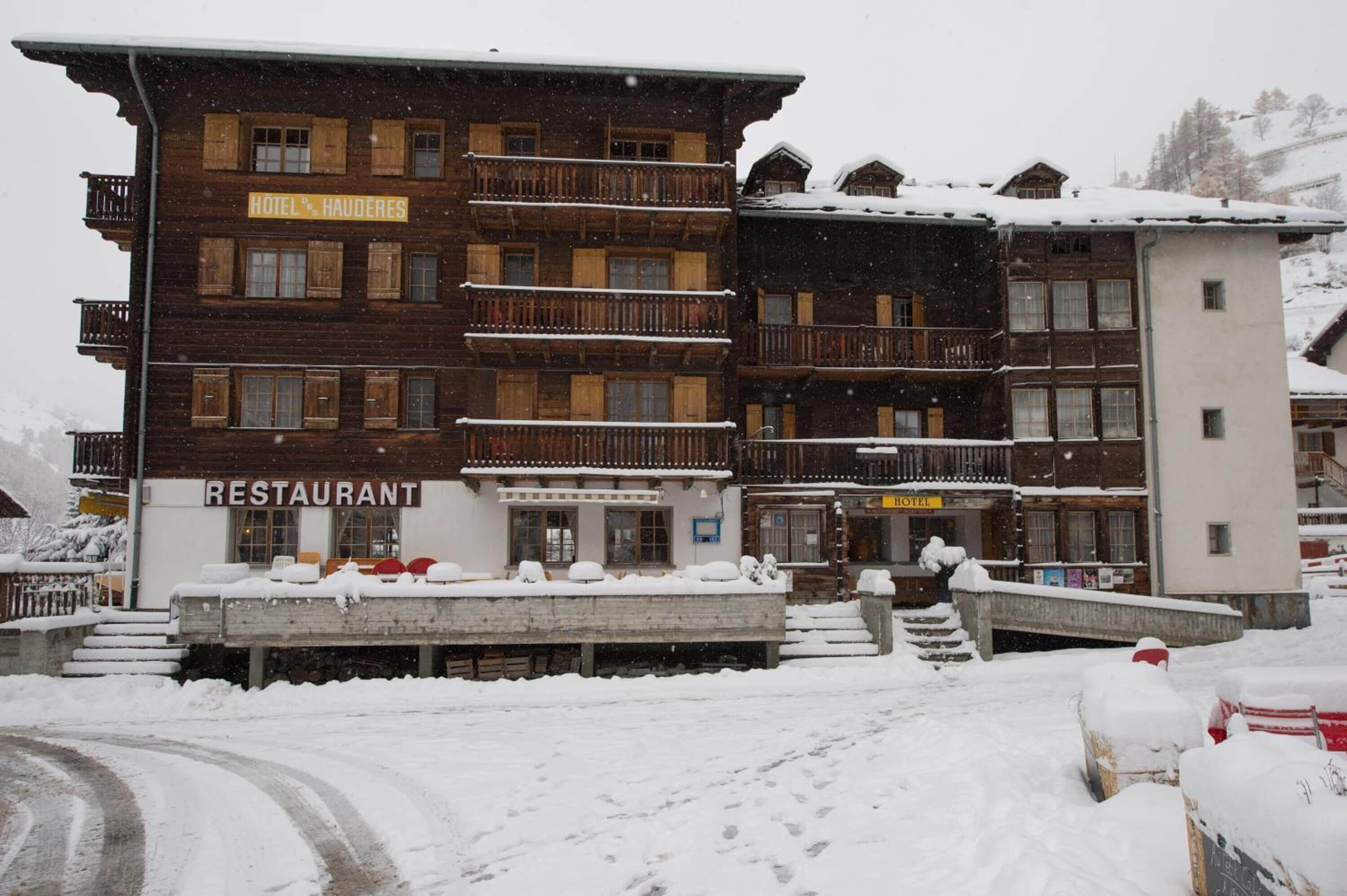 A multi-story wooden building with a restaurant and hotel signs.