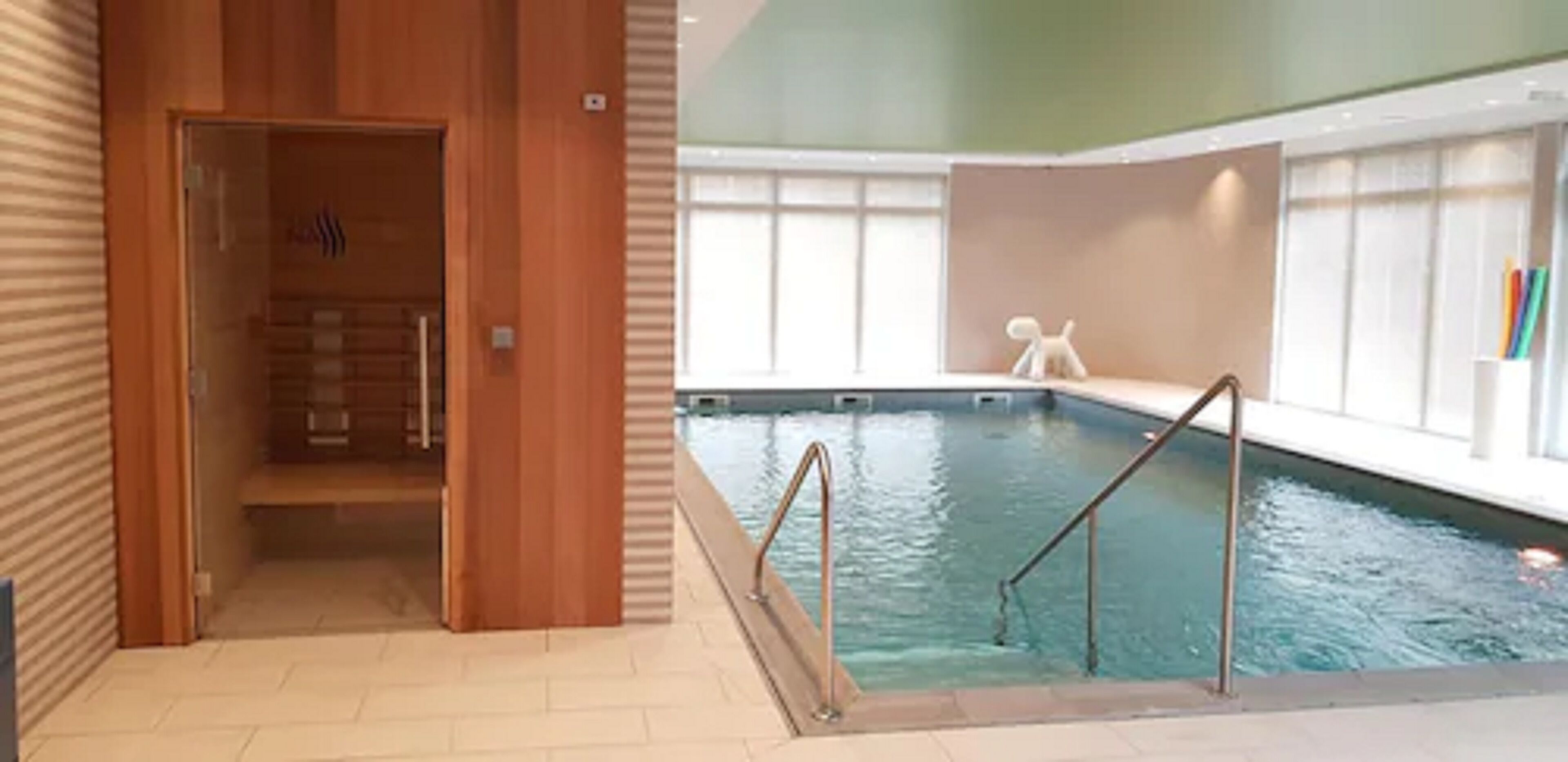Una piscina interna con pareti in legno e pavimento piastrellato.