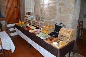 Una mesa de buffet con diversos alimentos y una máquina de café.