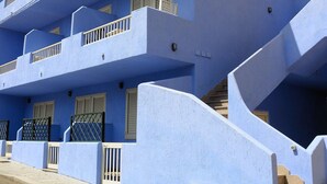 A multi-story building with blue exterior walls, balconies, and a staircase leading to the upper floors. - Residence Levante (Santa Teresa di Gallura)