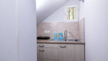 Apartamento standard, vista para o jardim | Cozinha americana privada | Geladeira, cooktop, talheres/pratos/utensílios de cozinha