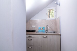 Departamento estándar, vista al jardín | Cocineta privada | Refrigerador, parrilla de estufa y utensilios de cocina
