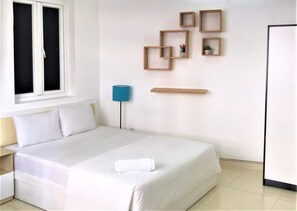 Une chambre d’hôtel bien rangée, avec un lit, une table de chevet, une lampe et des étagères murales ornées de plantes en pot.