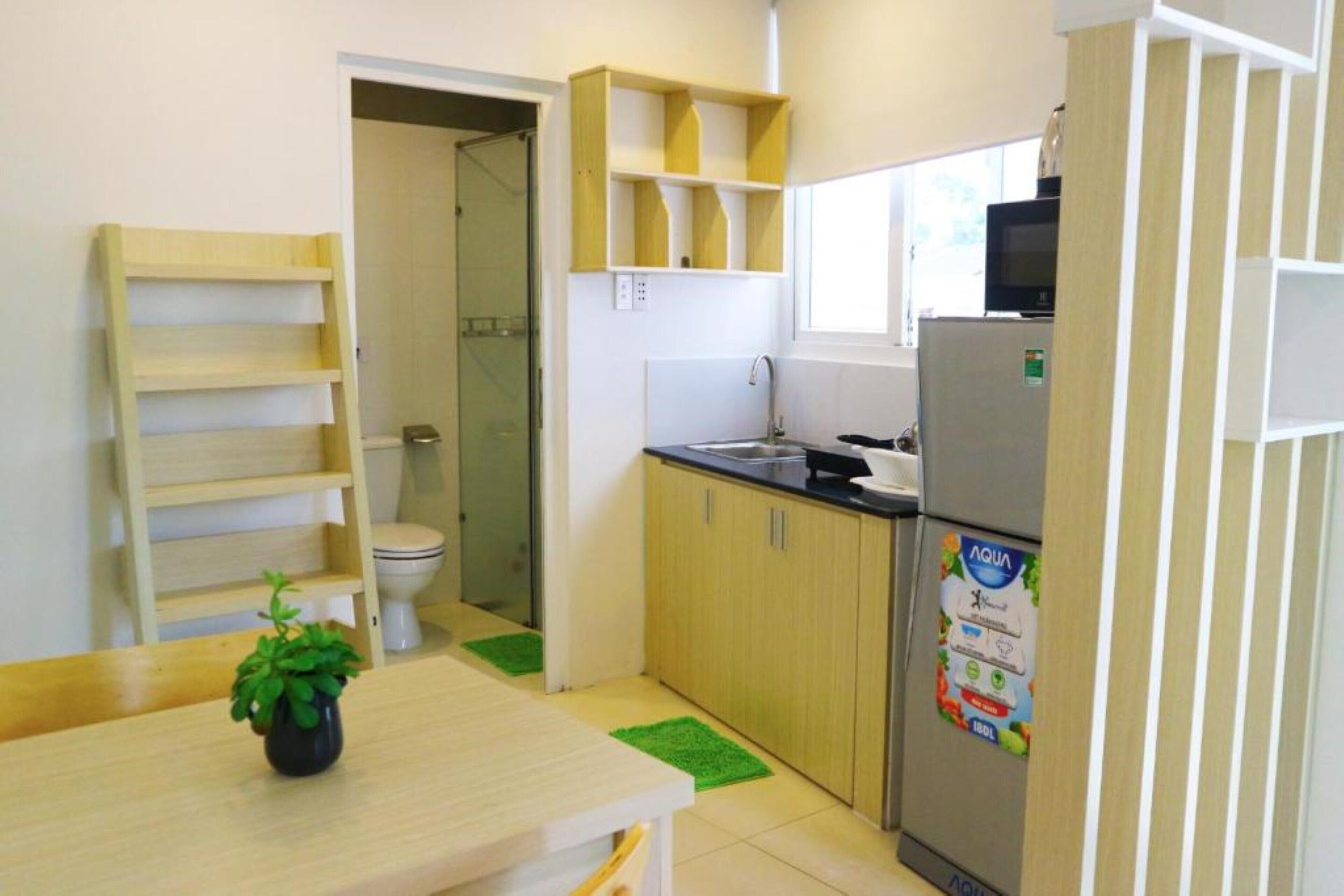A compact kitchen with a sink, refrigerator, and wooden cabinets.