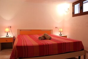 A neatly made bed with a striped bedspread and two bedside lamps. - Gemelle di Cairoli (Santa Teresa di Gallura)
