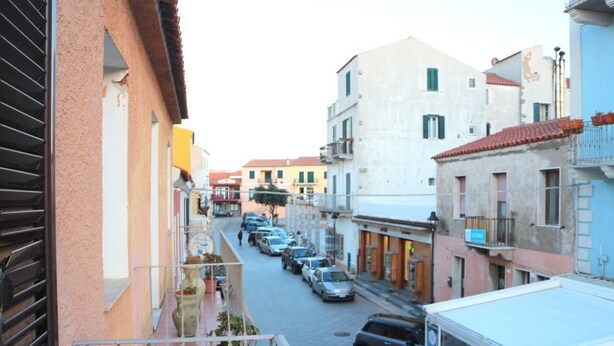 A narrow street with parked cars and buildings on both sides. - Casa di Anna (Santa Teresa di Gallura)