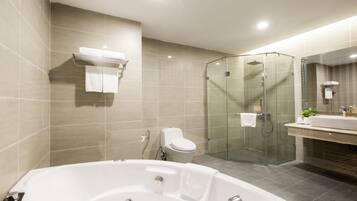 A modern bathroom with a glass-enclosed shower, a freestanding bathtub, and a vanity with a mirror.
