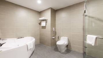 Un baño moderno con bañera, inodoro y cabina de ducha de vidrio.