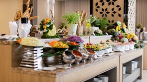 A buffet with various food items and decorative plants. - Muong Thanh Luxury Vien Trieu Hotel (Bac Nha Trang)