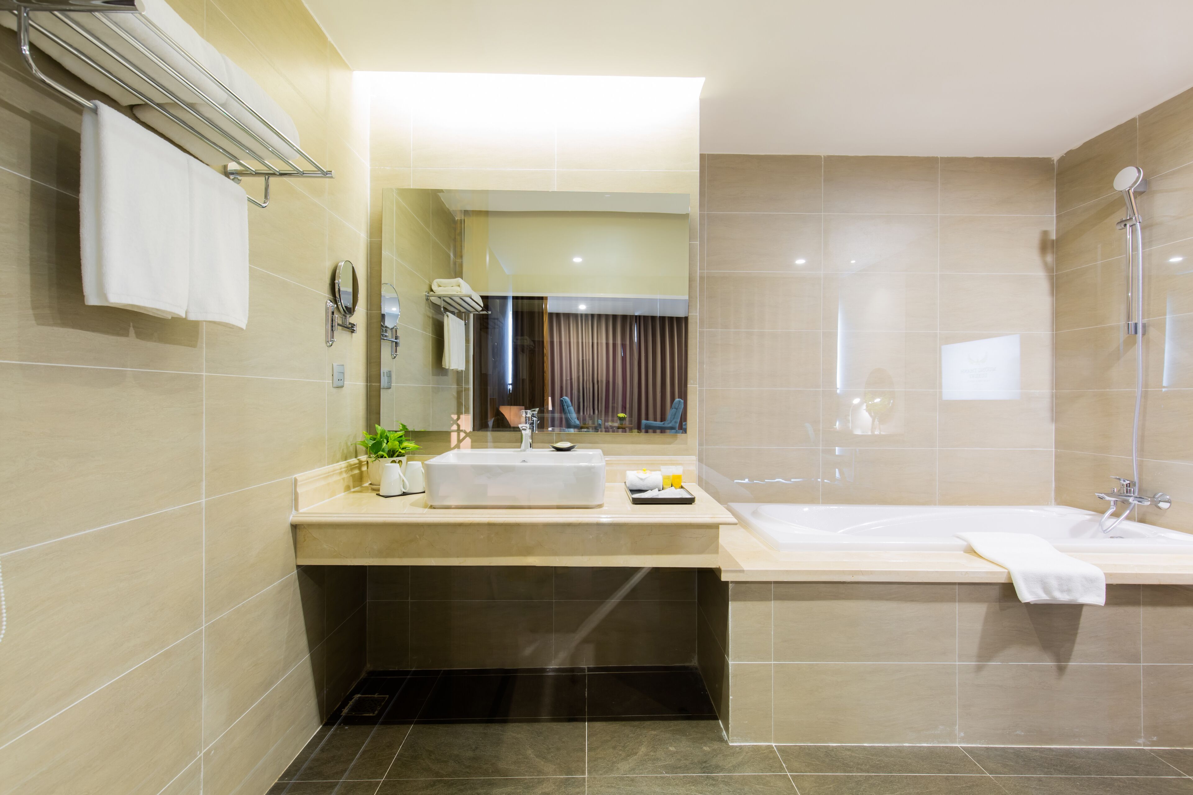 Un baño moderno con lavamanos, espejo y ducha.